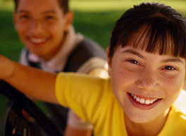 Dark-haired girl with boy in background